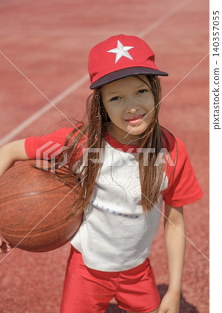 Portrait of a beautiful girl in a red sports cap with a basketball in her hand Portrait of a beautiful girl in a red sports cap with a basketball in her hand 140357055