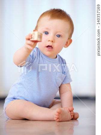 Baby, portrait and playing with wooden blocks or toys for childhood development on a gray studio background. Little boy, cute toddler or child on floor with shape or cube for building or learning Baby, portrait and playing with wooden blocks or toys for childhood development on a gray studio background. Little boy, cute toddler or child on floor with shape or cube for building or learning 140357169