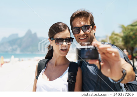 Couple, beach and camera for selfie on holiday with smile, sunglasses and outdoor for memory in summer. People, man and woman with photography by ocean for journey, vacation and sunshine in Italy Couple, beach and camera for selfie on holiday with smile, sunglasses and outdoor for memory in summer. People, man and woman with photography by ocean for journey, vacation and sunshine in Italy 140357209