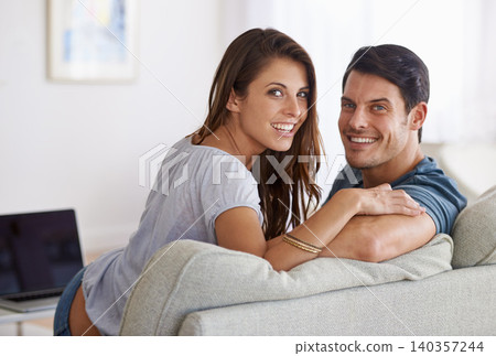 Happy couple, portrait and relax on sofa for bonding, holiday or weekend together at home. Face of young man and woman with smile for love, comfort or relationship on sofa in living room at house 140357244