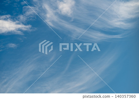 Delicate wispy clouds flowing quietly through open sky tranquil scene. Ethereal and fragile cloud ribbons gently glide across vast serene sky in peaceful display Delicate wispy clouds flowing quietly through open sky tranquil scene. Ethereal and fragile cloud ribbons gently glide across vast serene sky in peaceful display 140357360