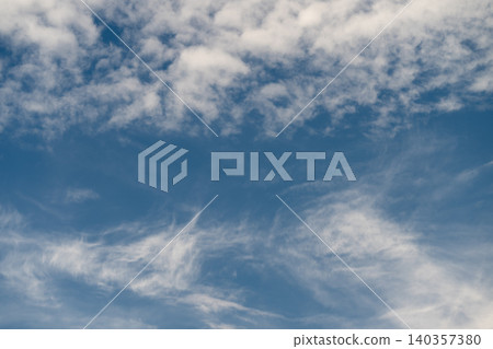 Fine textural cloud arrangements creating contrasting patterns in sky. Subtle and detailed cloud patterns displaying varying textures and streaks across open sky Fine textural cloud arrangements creating contrasting patterns in sky. Subtle and detailed cloud patterns displaying varying textures and streaks across open sky 140357380