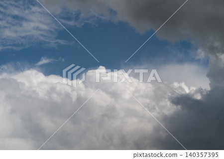 Vibrant clouds in clear sky. Sunlit clouds contrasting with open blue sky. Stunning dramatic sky showcasing luminous clouds vividly set against brilliant blue backdrop 140357395