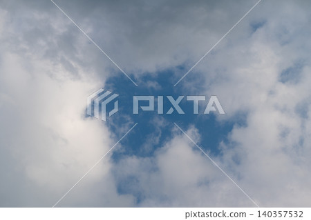 Bright sky contrasts shadows dramatically. Cloud breakthrough exposes vivid blue backdrop. Dramatic cloud emergence unveils vibrant blue expanse with striking shadowplay Bright sky contrasts shadows dramatically. Cloud breakthrough exposes vivid blue backdrop. Dramatic cloud emergence unveils vibrant blue expanse with striking shadowplay 140357532