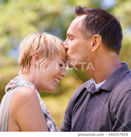 Couple, love and kiss on forehead with happiness in outdoor, affection and romance with date. Closeup, relationship and together with smile for bonding, care and trust with commitment for support Couple, love and kiss on forehead with happiness in outdoor, affection and romance with date. Closeup, relationship and together with smile for bonding, care and trust with commitment for support 140357939