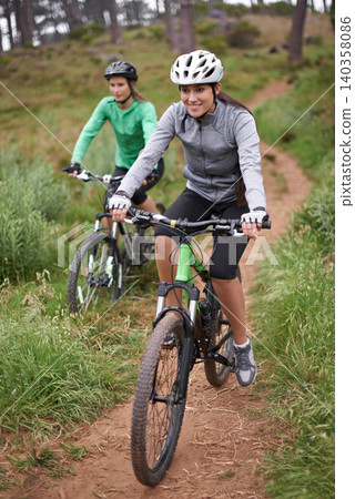 Happy woman, portrait and friends with bicycle for fitness, cycling or off road travel on trail in nature. Female person, rider or biker with smile in forest for workout or outdoor sports exercise Happy woman, portrait and friends with bicycle for fitness, cycling or off road travel on trail in nature. Female person, rider or biker with smile in forest for workout or outdoor sports exercise 140358086