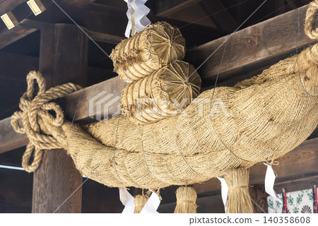 Traditional decorations of rice bales and hemp rope adorning the pillars of a shrine. Traditional decorations of rice bales and hemp rope adorning the pillars of a shrine. 140358608