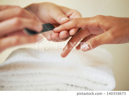 Hands, manicure and filing nails in salon for beauty treatment, relax or care. Closeup, spa and tool on fingernail, file and cosmetic service with professional, grooming and cleaning for wellness 140358673
