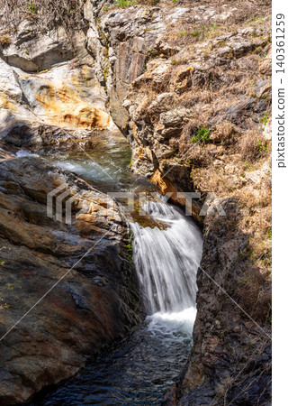A clear stream flowing over rocky terrain d-1 A clear stream flowing over rocky terrain d-1 140361259