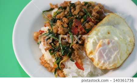 stir fried pork with holy basil on top with fried egg on cooked rice stir fried pork with holy basil on top with fried egg on cooked rice 140361736