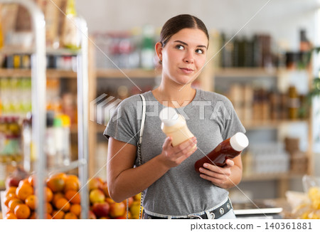 Woman choosing sauce in the store 140361881