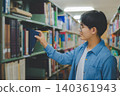 Male college students looking for books to study, making reports on bookshelves in the library.back to school concept 140361943