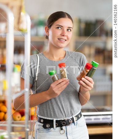Woman chooses spices and seasonings Woman chooses spices and seasonings 140362166