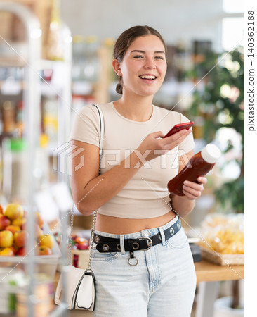Young woman scanning qr code for ketchup Young woman scanning qr code for ketchup 140362188