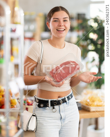 Young woman choose raw beef meat for roasting in store 140362371