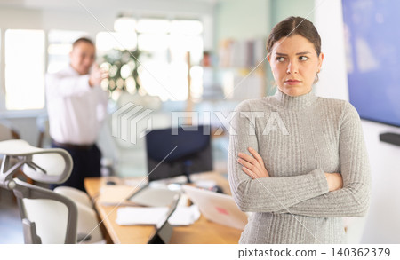 Young businessman of a large company, scolds his employee girl sitting at workdesk in office 140362379