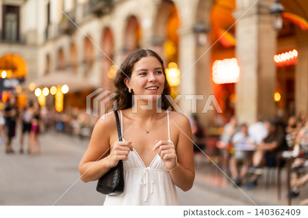 young woman walks through the evening streets of Barcelona 140362409