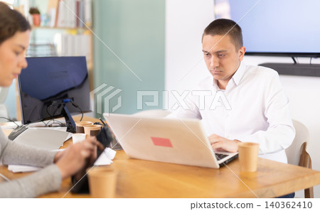 Adult man and young woman working in office Adult man and young woman working in office 140362410