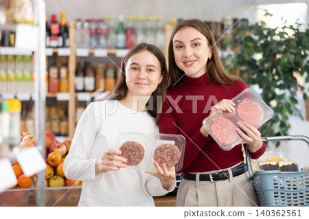 Mom and daughter choosing hamburgers Mom and daughter choosing hamburgers 140362561