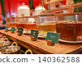 Variety of natural honey and sweet syrups in glass dispensers with wooden lids at luxury hotel breakfast buffet. Healthy organic Longan honey station for morning catering meal service display. 140362588