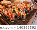 Fresh raw vegetable sticks of carrot and cucumber with cherry tomatoes served in small glass cups on a tray at a hotel breakfast buffet. Healthy vegan diet appetizer snack catering event display. 140362592
