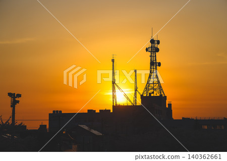 April 25 2026 Urban Communication Towers Silhouette Against Golden Sunset 140362661
