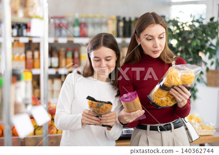 Teenage girl and her mother choosing pasta in grocery store Teenage girl and her mother choosing pasta in grocery store 140362744