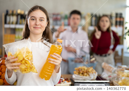Parents scold happy girl with chips and soda at grocery store Parents scold happy girl with chips and soda at grocery store 140362778