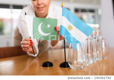Businesswoman arranging the flags of Argentina and Pakistan for presentation and negotiations Businesswoman arranging the flags of Argentina and Pakistan for presentation and negotiations 140362782