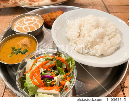 這是一家印度咖哩餐廳的套餐,包括米飯、沙拉和兩種咖哩:雞肉咖哩和海鮮咖哩。 這是一家印度咖哩餐廳的套餐,包括米飯、沙拉和兩種咖哩:雞肉咖哩和海鮮咖哩。 140363545