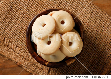 Traditional Brazilian Sequilho de Coco Cookies Served in Wooden Bowl on Rustic Burlap Background Traditional Brazilian Sequilho de Coco Cookies Served in Wooden Bowl on Rustic Burlap Background 140363691