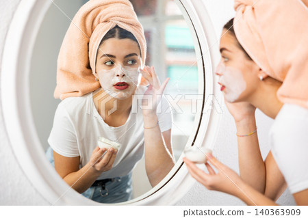 Young woman applying natural homemade facial mask Young woman applying natural homemade facial mask 140363909