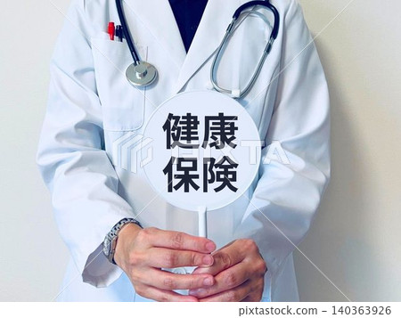 一位女醫生舉著一塊牌子,上面寫著「健康保險」。 一位女醫生舉著一塊牌子,上面寫著「健康保險」。 140363926
