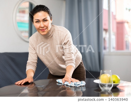 Woman washing table during cleanup Woman washing table during cleanup 140363940