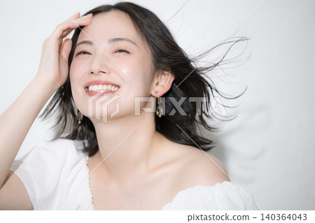 A close-up beauty image of a young woman with flowing hair and a radiant smile. A close-up beauty image of a young woman with flowing hair and a radiant smile. 140364043