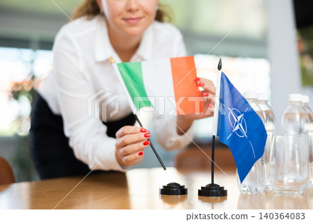 Young female secretary preparing room for international negotiations between nato and italy Young female secretary preparing room for international negotiations between nato and italy 140364083