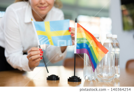 Unrecognizable girl sets midget flags of LGBT and Sweden before international negotiations Unrecognizable girl sets midget flags of LGBT and Sweden before international negotiations 140364254