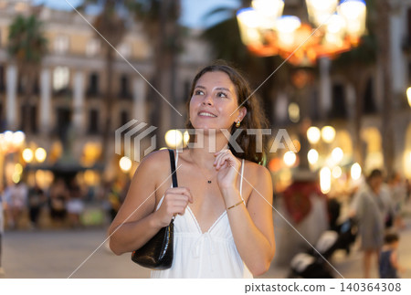 young woman walks through the evening streets of Barcelona young woman walks through the evening streets of Barcelona 140364308