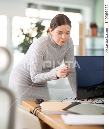Young woman works at computer in office Young woman works at computer in office 140364451