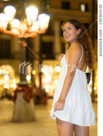 young woman walks along an evening street in Barcelona young woman walks along an evening street in Barcelona 140364516