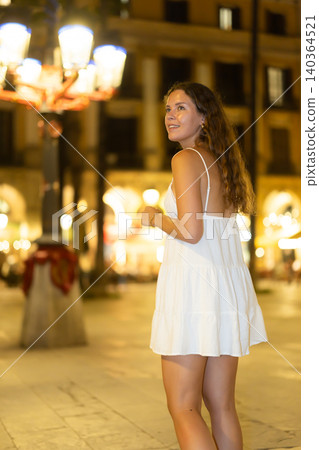 In night, young smiling girl walks along city street Placa Real In night, young smiling girl walks along city street Placa Real 140364521