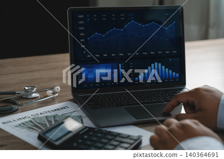 Person reviewing healthcare billing data on a laptop dashboard with charts, calculator, cash, and medical documents, supporting healthcare analytics, cost analysis, financial reporting, and data 140364691
