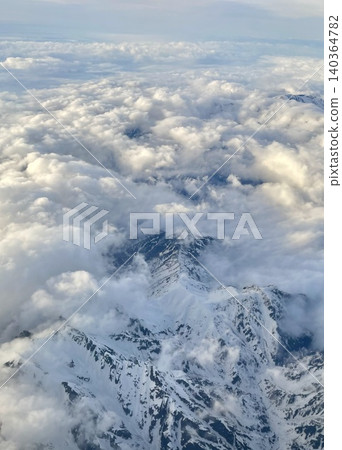 從飛機上可以看到無邊無際的雲海和白雪皚皚的山脈。 從飛機上可以看到無邊無際的雲海和白雪皚皚的山脈。 140364782