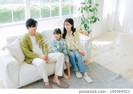 一位家長和孩子在明亮的客廳放鬆休息。 140364923