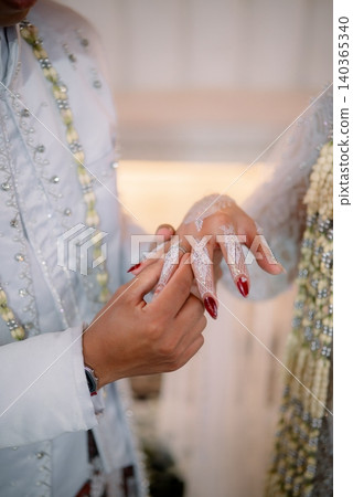The wedding ring exchange ceremony in a traditional Javanese wedding celebration. The wedding ring exchange ceremony in a traditional Javanese wedding celebration. 140365340