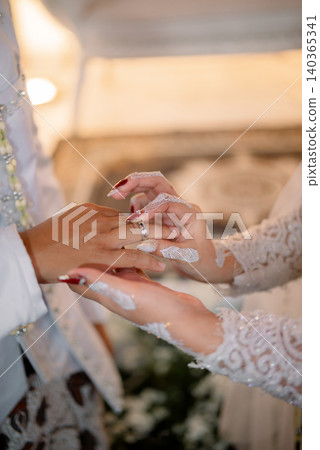 The wedding ring exchange ceremony in a traditional Javanese wedding celebration. The wedding ring exchange ceremony in a traditional Javanese wedding celebration. 140365341