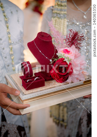 An elegant wedding jewelry presentation featuring a selection of rings, bracelets, and necklaces. 140365350