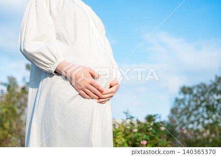 Pregnant woman touching stomach Pregnant woman touching stomach 140365370