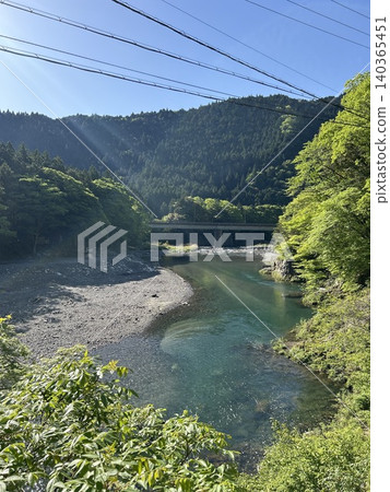 A clear stream flowing through the fresh green valley A clear stream flowing through the fresh green valley 140365451