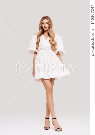 Blonde young woman in elegant white dress Blonde young woman in elegant white dress 140367244